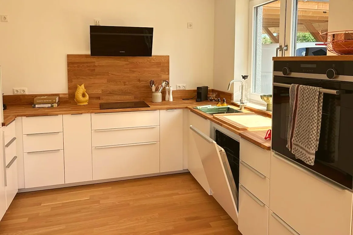 Moderne helle Küche mit Holzarbeitsplatte